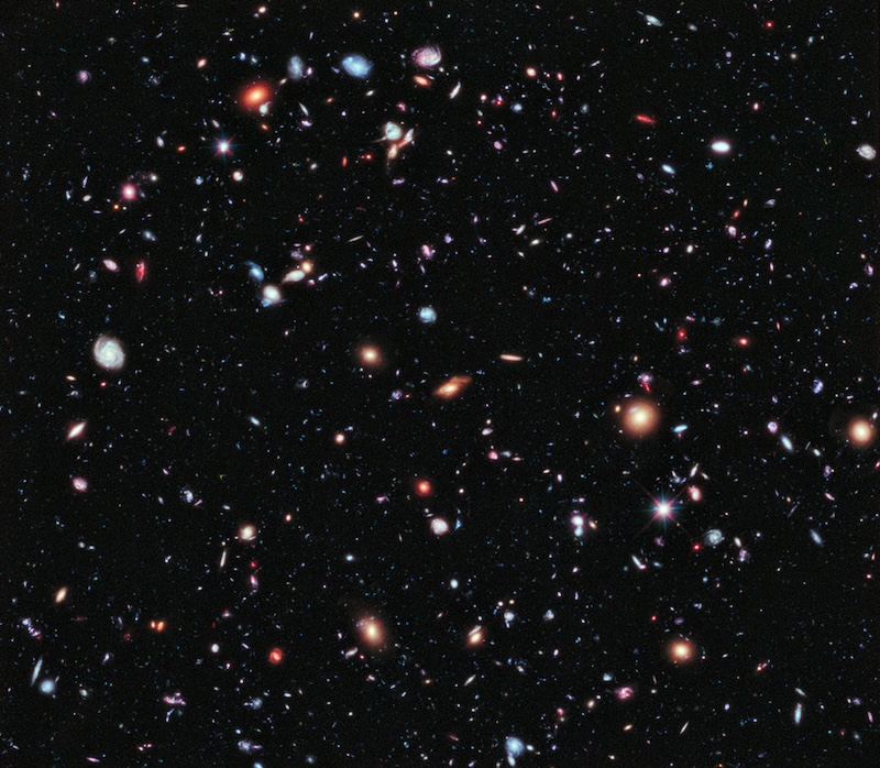 A colourful image showing hundreds of galaxies of different shapes and sizes.