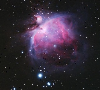 The Orion nebula is a hazy purple glow with bright stars at the core